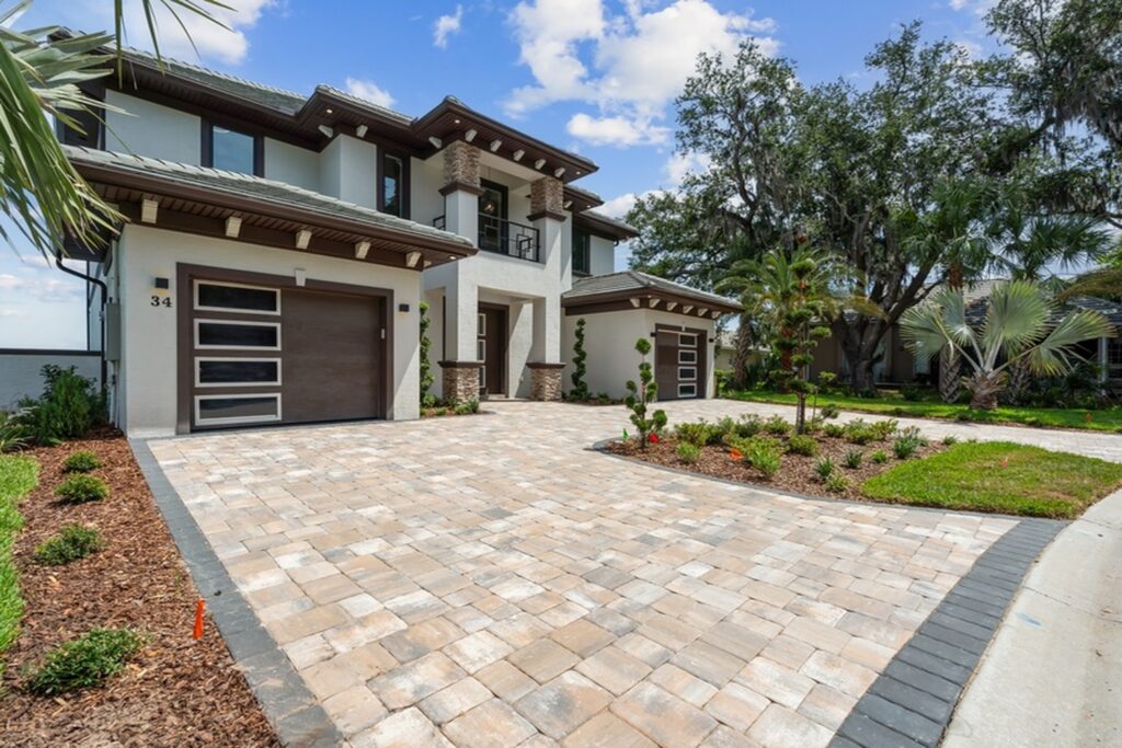 Front exterior of a two-story custom home with a paver driveway in Palm Coast